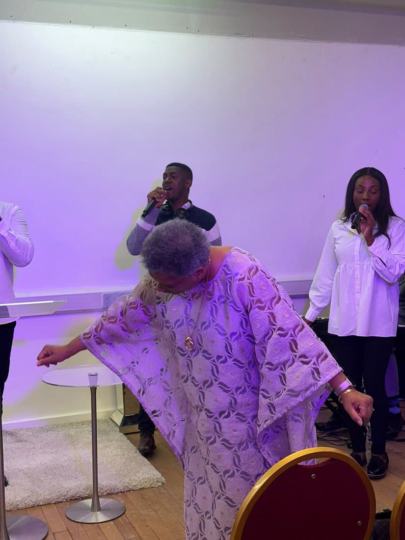 Minister Iris dancing in praise as the worship team sings