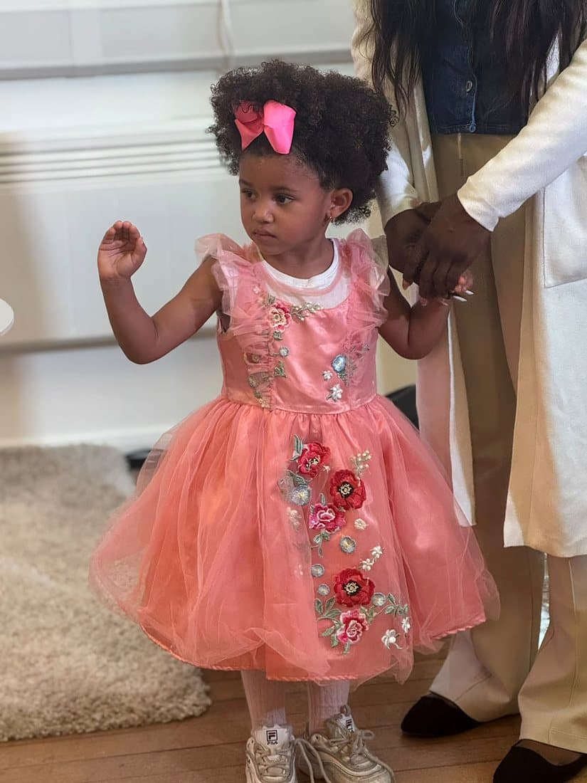 A little girl in a pink flowered dress at church