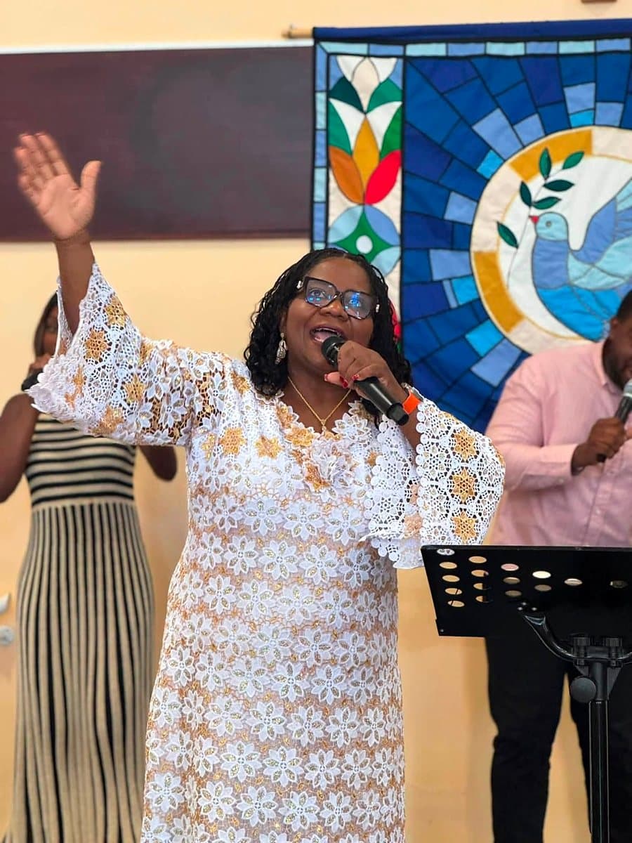 Pastor Catherine leading worship with her hand raised